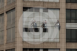 Group of workers cleaning windows service on high rise office building