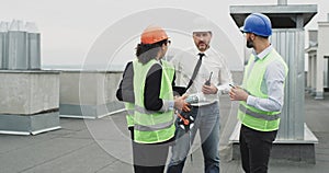 Group of workers in a construction site engineer architect businessmen have a meeting on the rooftop of construction