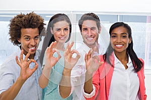 Group of workers giving OK gesture to camera