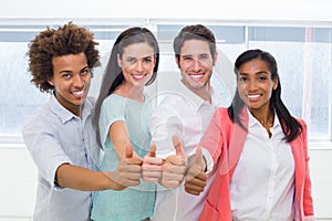 Group of workers giving thumbs up to camera