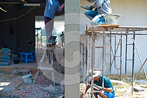 Group of workers plastering the cement on the bricklayer wall