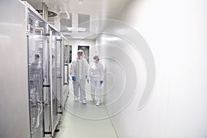 Group of workers in protective clothing in a sterile room of a f