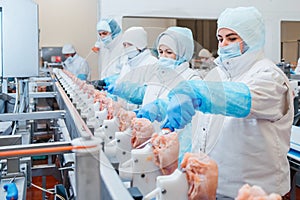 Group of workers working at a chicken factory - food processing plant concepts.Automated production line in modern food factory.