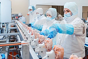 Group of workers working at a chicken factory - food processing plant concepts.Automated production line in modern food factory. photo