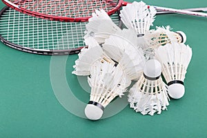 Group of worned out badminton shuttlecock with rackets on court