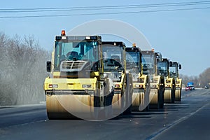 Group of yellow asphalt compactors on road