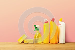 Group of yellow cleaning products on pink background