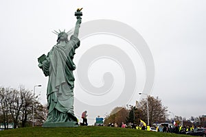 Group of yellow vests protesting near the statue of liberty replica against the sanitary pass