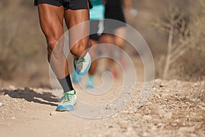 People trail running on a mountain path