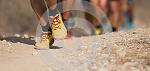 People trail running on a mountain path