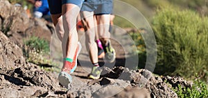 People trail running on a mountain path