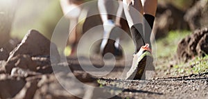 People trail running on a mountain path