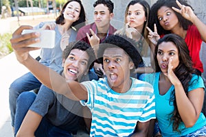 Group of young adults making funny selfie shots with phone