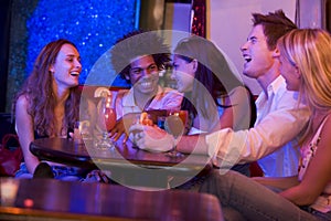 Group of young adults in a nightclub talking photo