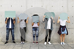 Group of young adults outdoors holding empty placard copyspace t