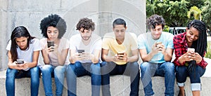 Group of young adults playing online game with phone photo