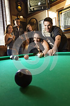 Group of young adults playing pool.