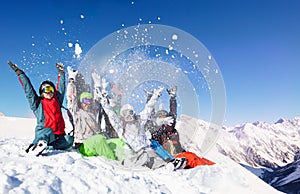 Group of young adults throw snow up in the air