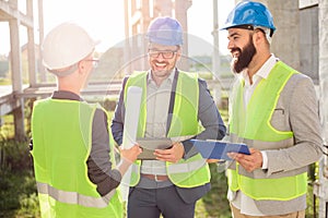 Group of young architects or business partners meeting on a construction site