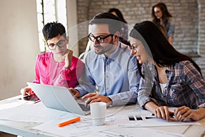 Group of young architects working on computer