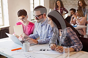 Group of young architects working on computer