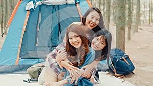 Group of young asia camper friends camping near relax enjoy moment in forest. Female traveler using smartphone taking selfie at