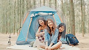 Group of young asia camper friends camping near relax enjoy moment in forest. Female traveler using smartphone taking selfie at