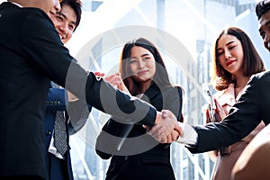 Group of young Asian achievement successful businesspeople shaking hands after sign contract, corporate group clapping hands and