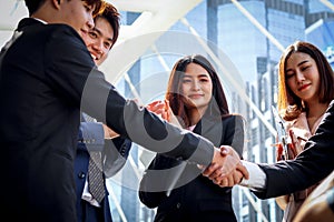Group of young Asian achievement successful businesspeople shaking hands after sign contract, corporate group clapping hands and