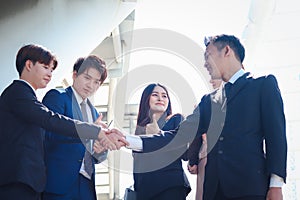 Group of young Asian achievement successful businesspeople shaking hands after sign contract, corporate group giving thumbs up and