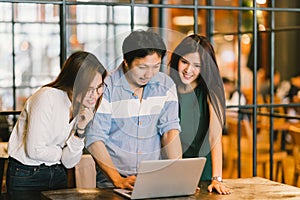 Group of young Asian business colleagues in team casual discussion, startup business meeting or teamwork brainstorm concept