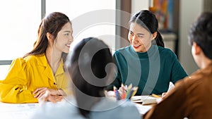 Group of young Asian business people or creative team in brainstorm discussion meeting in office. Female coworker lead team talk photo