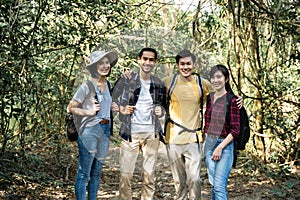 Group of young Asian man and woman friend traveling in the forest together. They are feeling fresh and relax in nature wild, looki