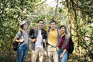 Group of young Asian man and woman friend traveling in the forest together. They are feeling fresh and relax in nature wild, looki