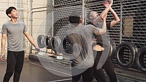 Group young asian men playing basketball outdoors