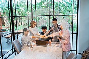 group of young asian people with hand gesture of unity