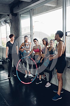 Group of young asian people in sportswear talking after a workout in gym