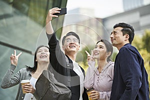 Group of young asian people taking a selfie together outdoors