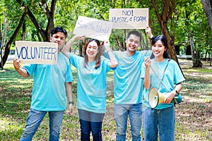 A group of young Asian volunteers hold a placard for good deeds.