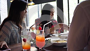 Group of young Asian women eating and talking at cafe and restaurant