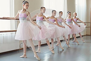 Group of young ballerinas practicing dance at classical ballet school