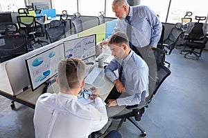 Group of young business men in formalwear working using computers while sitting in the office