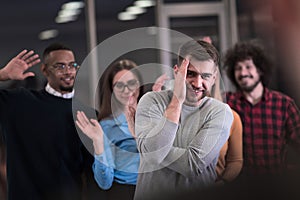 A group of young business people have fun playing interesting games while taking a break from work in a modern office