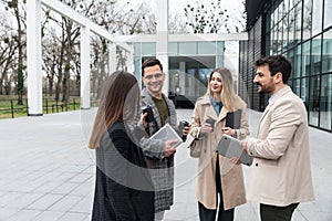 Group of young business people, job candidates standing in front of the office building waiting to be called to meeting with the