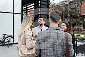 Group of young business people, job candidates standing in front of the office building waiting to be called to meeting with the
