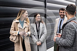 Group of young business people, job candidates standing in front of the office building waiting to be called to meeting with the