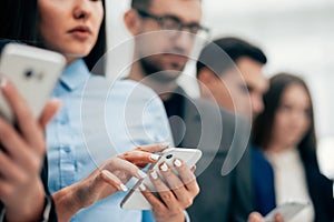 group of young business people reading messages on their smartphones