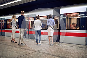 Group of young business people at subway station waiting for a train