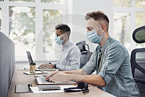 Group of young business people working in office wearing medical protective mask