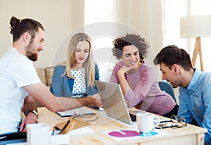 Group of young businesspeople with laptop working in a modern office.